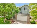 Charming two-story home with a brick-accented garage, well-manicured lawn, and mature trees at 10571 Garfield St, Thornton, CO 80233