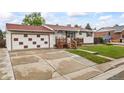 Charming home boasts a well-maintained lawn and an attached garage with unique detailing at 6327 Fenton St, Arvada, CO 80003