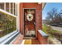 Welcoming front door with decorative wreath, window and brick facade at 2023 E 20Th Ave, Denver, CO 80205