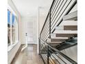 Bright foyer showcasing a modern staircase and hardwood floors, complemented by a large window at 3632 Lipan St, Denver, CO 80211