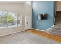 Bright living room with vaulted ceilings, large window, modern tv wall, and carpeted stairs at 10517 Madison St, Thornton, CO 80233