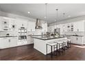 Bright kitchen with white cabinets, black countertops, stainless steel appliances, and island with seating at 2230 Rim Ridge Dr, Castle Pines, CO 80108