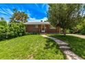 Inviting brick home with a lush green lawn and mature trees at 3182 W Radcliff Dr, Englewood, CO 80110