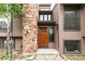 Close up of the front door with stone chimney and walkway at 3260 Bit Rd, Evergreen, CO 80439
