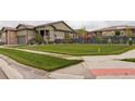 Well-maintained front yard with lush green lawn, tasteful landscaping and exterior of home in background at 7029 Sagerock St, Castle Pines, CO 80108