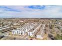 Wide angle aerial view of townhouses in neighborhood with mature trees and distant skyline view at 1169 S Reed Way, Lakewood, CO 80232