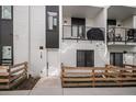 Modern townhouse exterior with black framed windows, white siding, a small patio area, and front door at 1169 S Reed Way, Lakewood, CO 80232