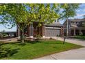 Charming two-story home with a well-manicured lawn, a two-car garage, and a welcoming front porch at 14803 E 119Th Ave, Commerce City, CO 80603