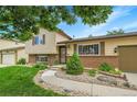 Welcoming split level with a well-manicured lawn and landscaped garden area at 10301 Owens Cir, Broomfield, CO 80021