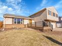 Charming split-level home with tan siding, brick accents, and a spacious front deck at 11535 Albion Ct, Thornton, CO 80233