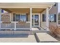 Inviting covered front porch with white railings, decorative flower boxes, and a glass-paneled front door at 4206 Eagle Ridge Way, Castle Rock, CO 80104