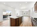Bright, modern kitchen with a large island, stainless steel appliances, and sliding door access to the deck at 2070 Wagon Wheel Aly, Brighton, CO 80601