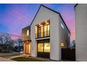 Striking exterior view of the modern home, emphasizing its architectural lines and contrasting materials against the evening sky at 4398 N Pecos St, Denver, CO 80211