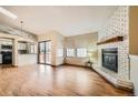 Open-concept living room featuring wood floors, brick fireplace and access to the kitchen at 17949 E Ohio Cir, Aurora, CO 80017