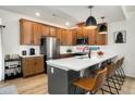 Modern kitchen features wood cabinets, stainless steel appliances, and an island with bar seating at 10149 Xanadu Street, Commerce City, CO 80022