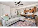 Open-concept living space with kitchen, cozy gray sofa, and a colorful area rug at 10149 Xanadu Street, Commerce City, CO 80022