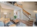 Inviting living room features wood floors, a leather couch, and an open staircase to an upper loft at 804 Summer Dr, Highlands Ranch, CO 80126