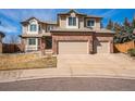 Charming two-story home featuring a brick facade, dormer windows, and a two-car garage at 15407 E Crestline Pl, Centennial, CO 80015