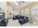 Bright living room featuring high ceilings, large arched windows, and a comfortable sectional sofa with stylish decor at 15407 E Crestline Pl, Centennial, CO 80015