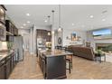 Open-concept kitchen and living area featuring an island, modern appliances, and a cozy living space at 17358 W 95Th Ave, Arvada, CO 80007