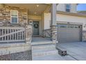 Inviting front porch with stone pillars, railing, and a wreath on the front door at 24274 E Walsh Ave, Aurora, CO 80018