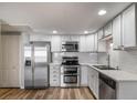 Bright kitchen featuring stainless steel appliances, white cabinets, and sleek countertops at 1697 S Cole St # B5, Lakewood, CO 80228