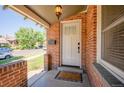 A welcoming front entry featuring a classic white door and a brick facade with a charming porch light at 4322 Decatur St, Denver, CO 80211