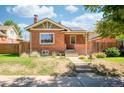 Charming brick home featuring a well-maintained front yard and a welcoming porch at 4322 Decatur St, Denver, CO 80211