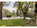A lush front yard with mature trees, green grass, and beautiful landscaping adds to the home's curb appeal at 4121 S Cherry St, Cherry Hills Village, CO 80113