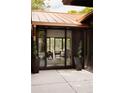 An outdoor patio featuring spiral topiary plants, leading to open sliding doors and a glimpse of the stylish living room at 4121 S Cherry St, Cherry Hills Village, CO 80113