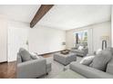 Staged living room with neutral tones, hardwood floors, and an exposed wood beam on the ceiling at 16359 W 10Th Ave # Yy3, Golden, CO 80401