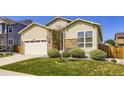 Well-maintained front yard and exterior view of a two-story home with an attached garage at 6863 E 132Nd Pl, Thornton, CO 80602