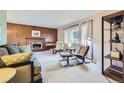 Inviting living room with fireplace, wood paneling, plush seating, and large window with great natural light at 4257 Graham Ct, Boulder, CO 80305