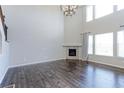 Open-plan living room featuring wooden floors, a fireplace, large windows, and a vaulted ceiling at 2474 Ravenswood Ct, Longmont, CO 80504