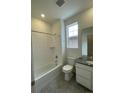 Bright bathroom features a shower over tub, a toilet, and a vanity with modern finishes at 5025 N Quemoy St, Aurora, CO 80019