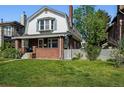 Inviting two-story home with a covered porch, brick accents, and lush green lawn at 618 S Franklin St, Denver, CO 80209
