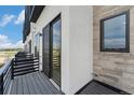 Private balcony featuring modern railings, sliding glass door and a stone accent wall at 2323 Lakeshore Ln # 11, Superior, CO 80027