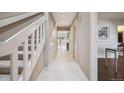 Bright hallway with tile flooring, leading to the living areas and staircase with white banister at 345 Harrison St, Denver, CO 80206