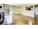 Open living room with hardwood floors, fireplace, and sliding door to the backyard at 11771 Pennsylvania St, Northglenn, CO 80233