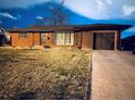 Well-kept single-story brick home with attached garage and manicured front lawn at 413 Jamaica St, Aurora, CO 80010