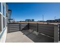 Outdoor patio featuring gray horizontal fencing and a view of nearby buildings at 16261 Bolling Dr, Denver, CO 80239