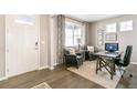 Well lit office and study features dark wood flooring, large windows, modern desk and comfortable seating at 3418 Belleville Ridge Rd, Elizabeth, CO 80107