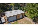 Large detached garage with a white metal roof, two garage doors and a small fenced gravel backyard at 8178 W 64Th Ave, Arvada, CO 80004