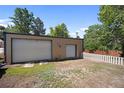 Spacious detached garage with a white metal roof, two doors, and a small fenced backyard at 8178 W 64Th Ave, Arvada, CO 80004