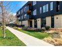 Modern apartment building featuring black wood facade, balconies, and green lawn at 2718 Pine St # 305, Boulder, CO 80302