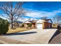 Spacious brick home with a long driveway, attached garage, and mature trees at 9241 Knox Ct, Westminster, CO 80031