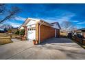 Brick home with attached garage and concrete driveway at 9241 Knox Ct, Westminster, CO 80031