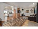 Cozy living room featuring hardwood floors, a wood-burning stove, a TV, and lots of natural light at 576 S Tabor St, Elizabeth, CO 80107