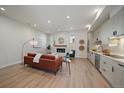 Open-concept living room and kitchen featuring hardwood floors, a fireplace and modern appliances at 1372 Lowell Blvd # 4, Denver, CO 80204