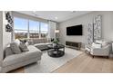 Bright and airy living room featuring a large window, comfortable gray sectional, and contemporary decor at 9445 W 58Th Cir # B, Arvada, CO 80002